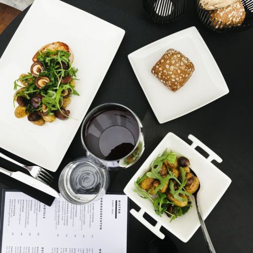 Vierkant Squito bord 16 cm van porselein met logo, gevuld en geplaatst in een sfeerruimte.