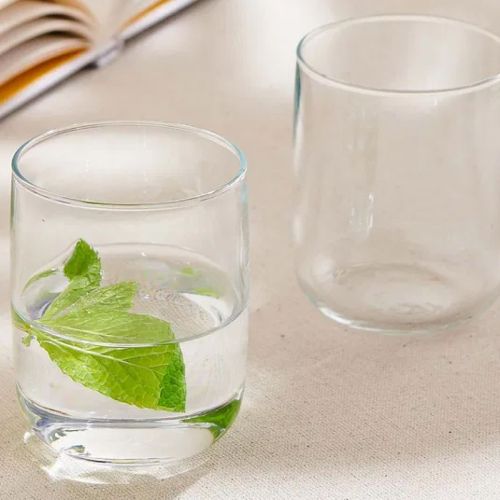 Iconic Tumbler 27 cl. glas met drank en bedrukt logo, geplaatst in moderne sfeerruimte.