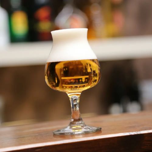 Gevuld bierglas Specials Tasting 25 cl. in sfeervolle setting, geplaatst op houten tafel. Gevuld bierglas Specials Tasting 25 cl. in sfeervolle setting, geplaatst op houten tafel.