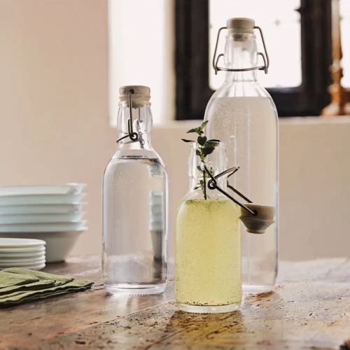 Emilia Fles van 1 liter met beugelsluiting en vulling, met bedrukt logo in keukenomgeving. Emilia Fles van 1 liter met beugelsluiting en vulling, met bedrukt logo in keukenomgeving.